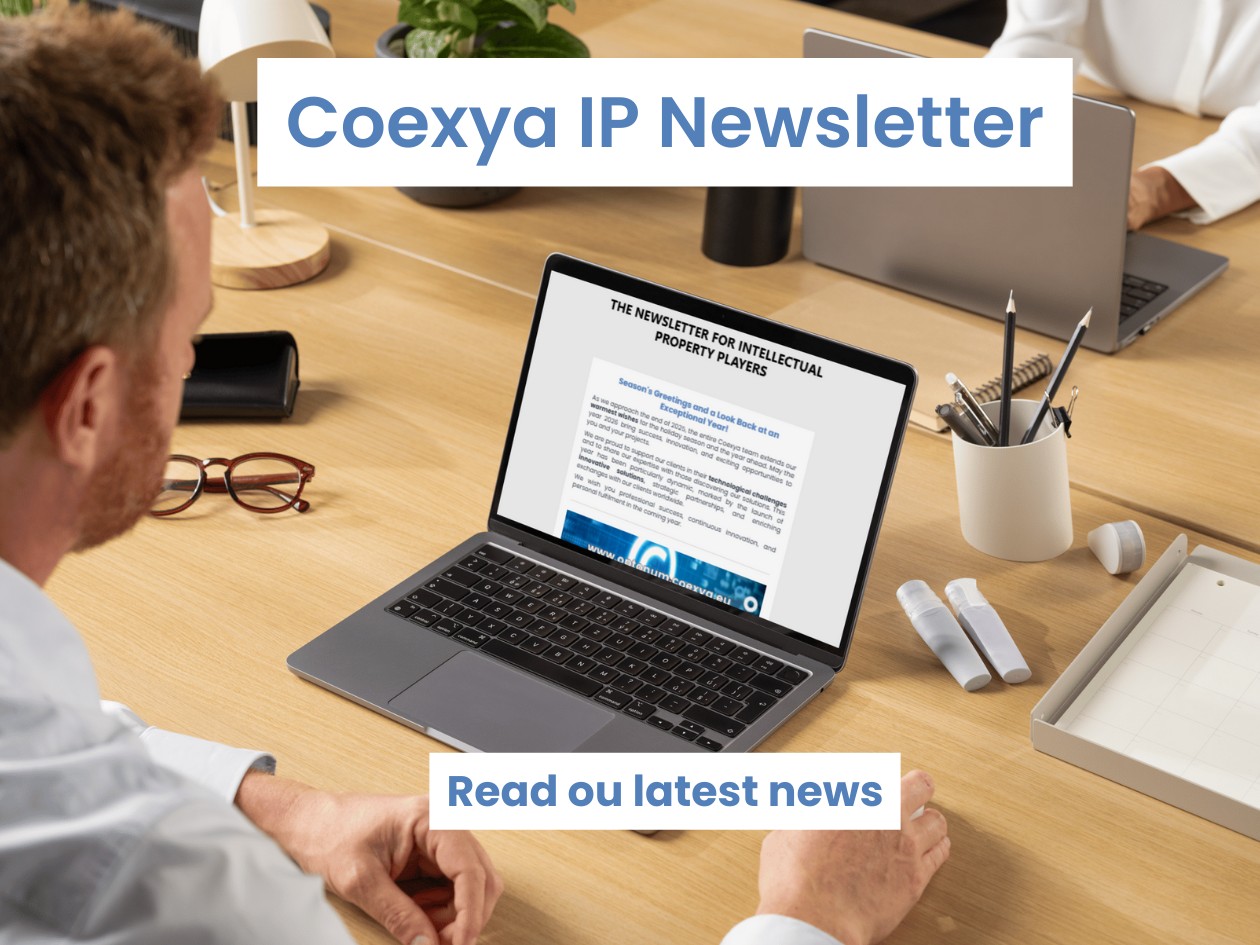 Image of a man at his desk reading a newsletter on his computer to illustrate the release of Coexya's newsletter on intellectual property.