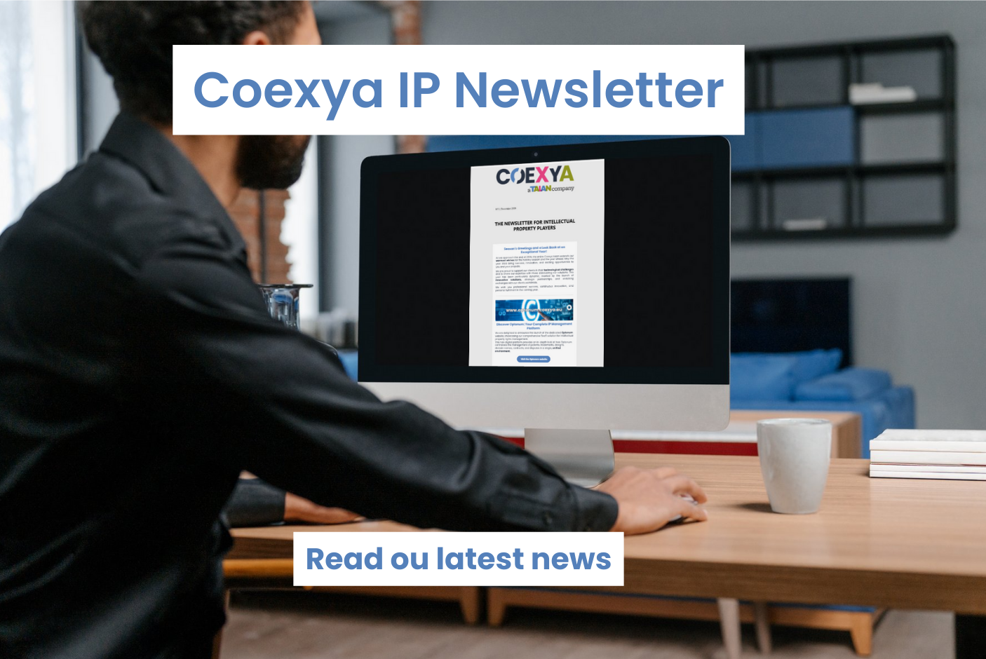 Image of a man at his desk reading a newsletter on his computer to illustrate the release of Coexya's newsletter on intellectual property.