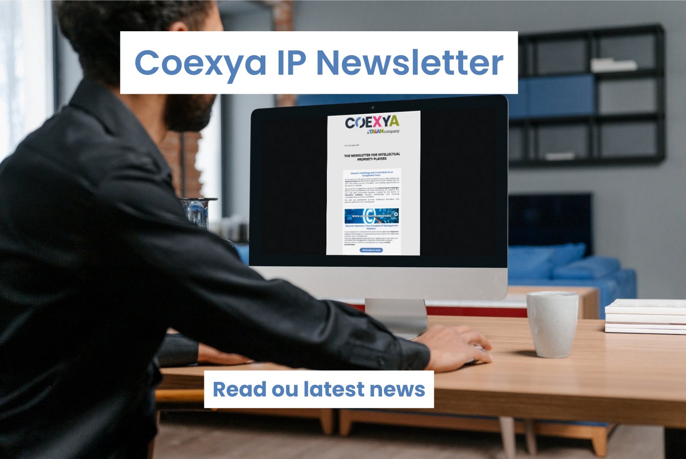 Image of a man at his desk reading a newsletter on his computer to illustrate the release of Coexya's newsletter on intellectual property.